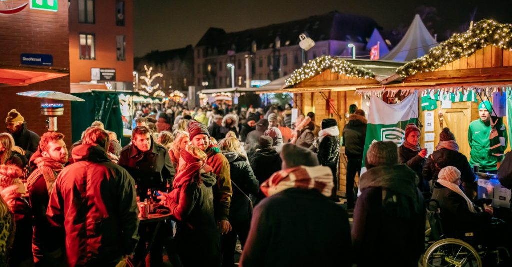 Mensen in het donker op de kerstmarkt