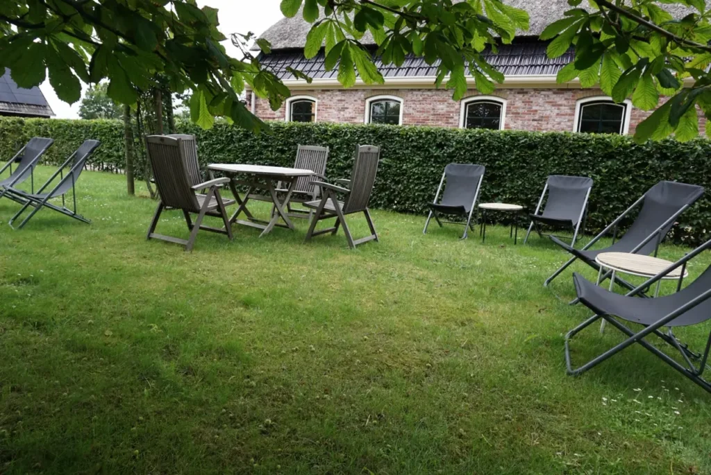 omheinde weide met tuinmeubels en bomen